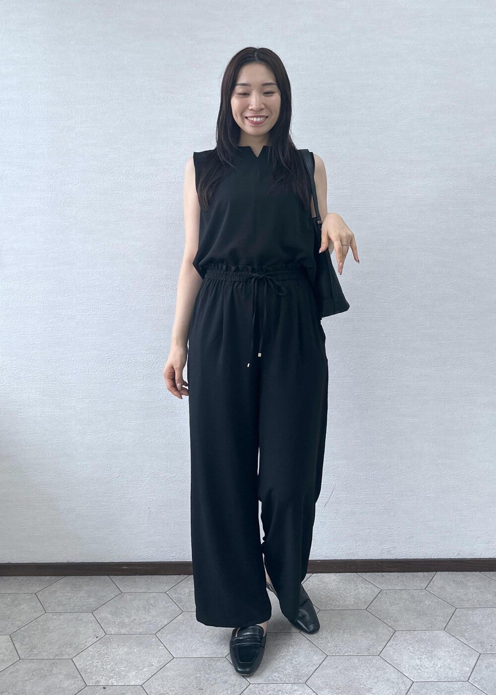 ブラック系のローファー、ブラック系のショルダーバッグ、ブラック系のその他パンツを着用したレディースの夏コーディネートの2枚目の写真