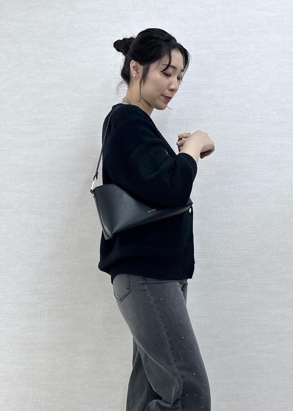 シルバー系のバレエシューズ、ブラック系のデニムパンツ、ブラック系のショルダーバッグを着用したレディースの冬コーディネートの7枚目の写真