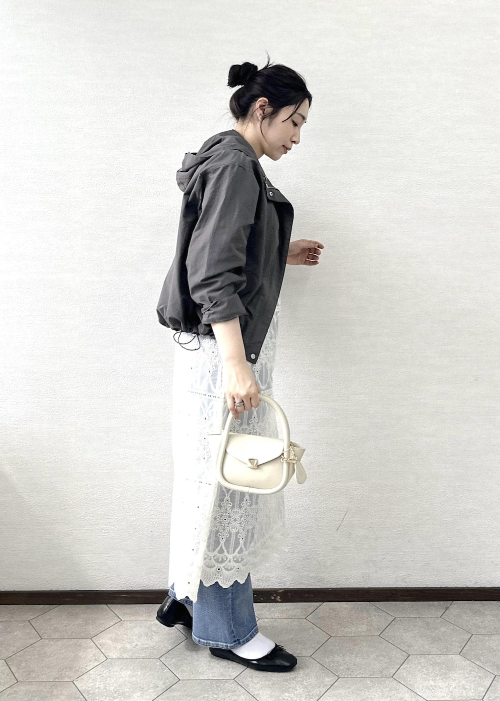 ブルー系のデニムパンツ、ホワイト系のワンピース、ホワイト系のタンクトップを着用したレディースの春コーディネートの4枚目の写真