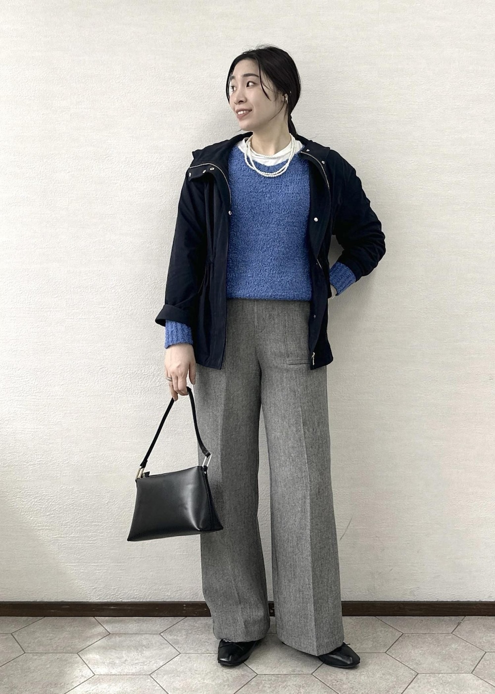 ブラック系のショルダーバッグ、ブルー系のニット/セーター、グレー系のその他パンツを着用したレディースの春コーディネートの2枚目の写真