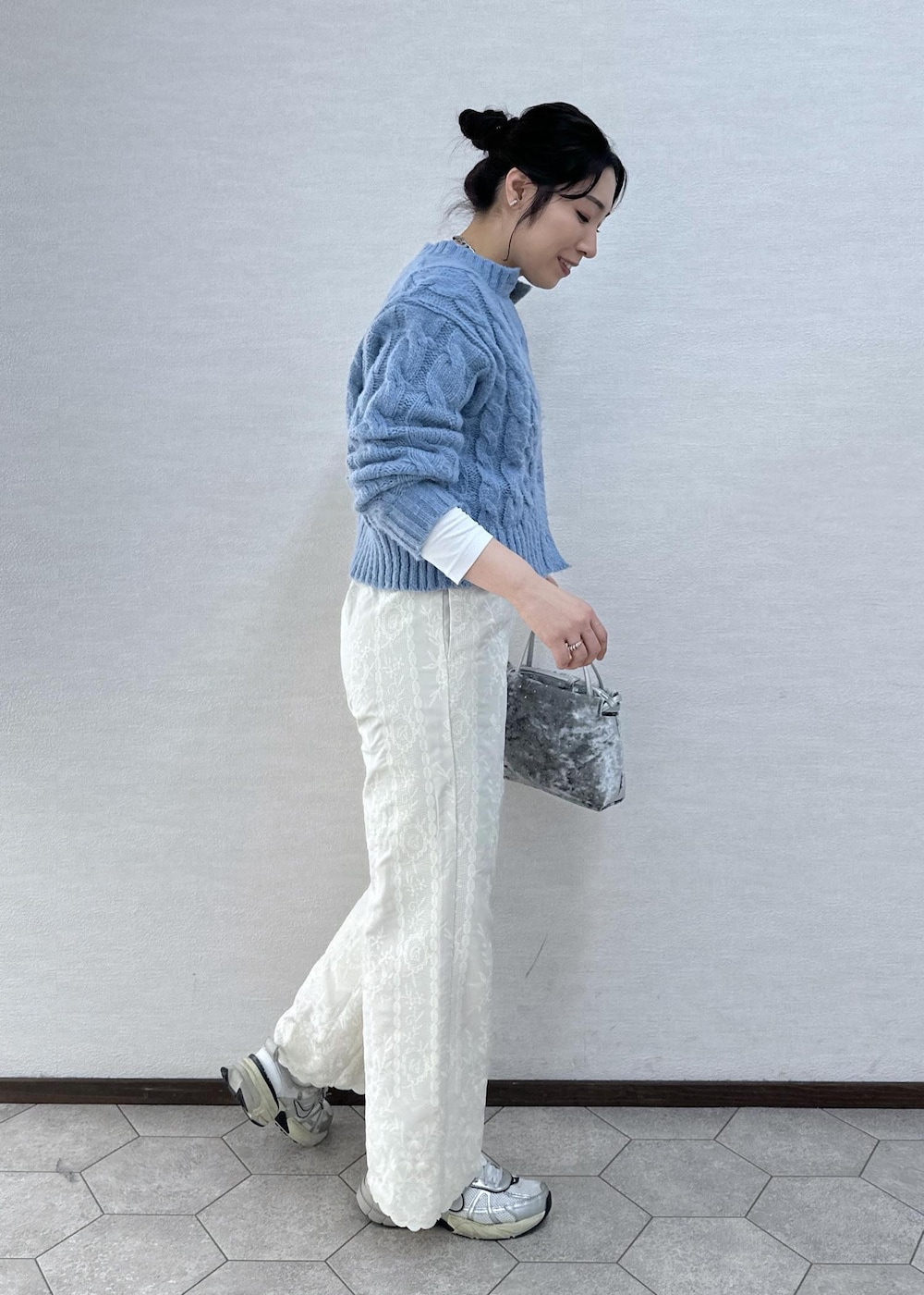 シルバー系のハンドバッグ、ホワイト系のその他パンツ、ブルー系のカーディガン/ボレロを着用したレディースの冬コーディネートの4枚目の写真