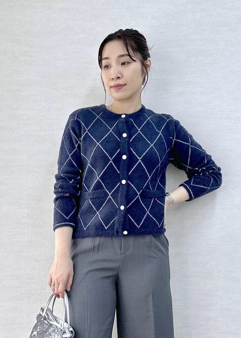 グレー系のその他パンツ、ブルー系のカーディガン/ボレロ、ブラック系のダウンジャケット/コートを着用したレディースの冬コーディネートの6枚目の写真