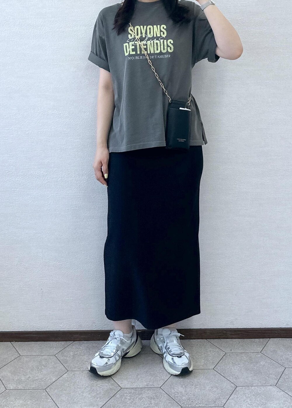 ブラック系のスカート、グレー系のTシャツ/カットソー、ブラック系のショルダーバッグを着用したレディースの夏コーディネートの6枚目の写真
