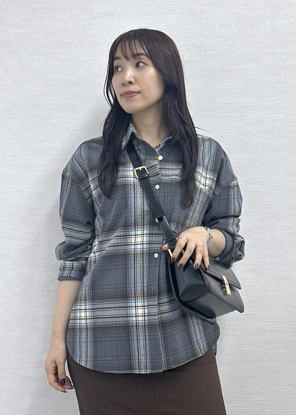 ブラウン系のスカート、ブラック系のショルダーバッグ、グレー系のシャツ/ブラウスを着用したレディースの秋コーディネートの8枚目の写真