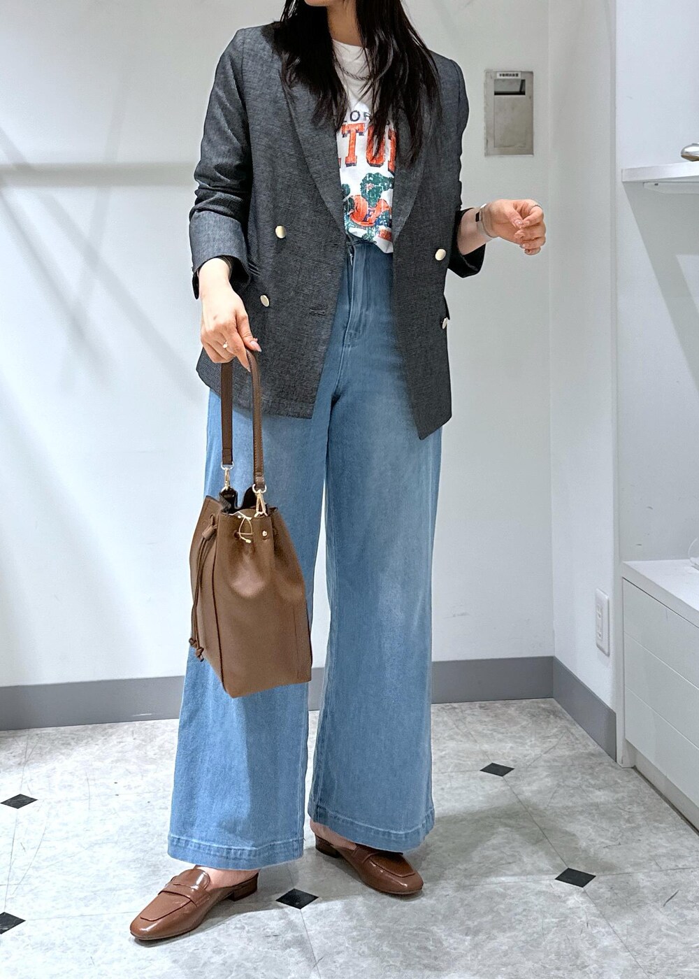 ブルー系のデニムパンツ、イエロー系のローファー、ブラウン系のショルダーバッグを着用したレディースの夏コーディネートの9枚目の写真