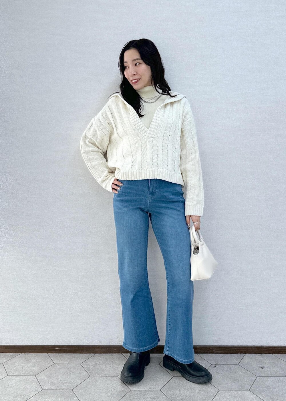 ホワイト系のニット/セーター、ホワイト系のニット/セーター、ブルー系のデニムパンツを着用したレディースの冬コーディネートの2枚目の写真