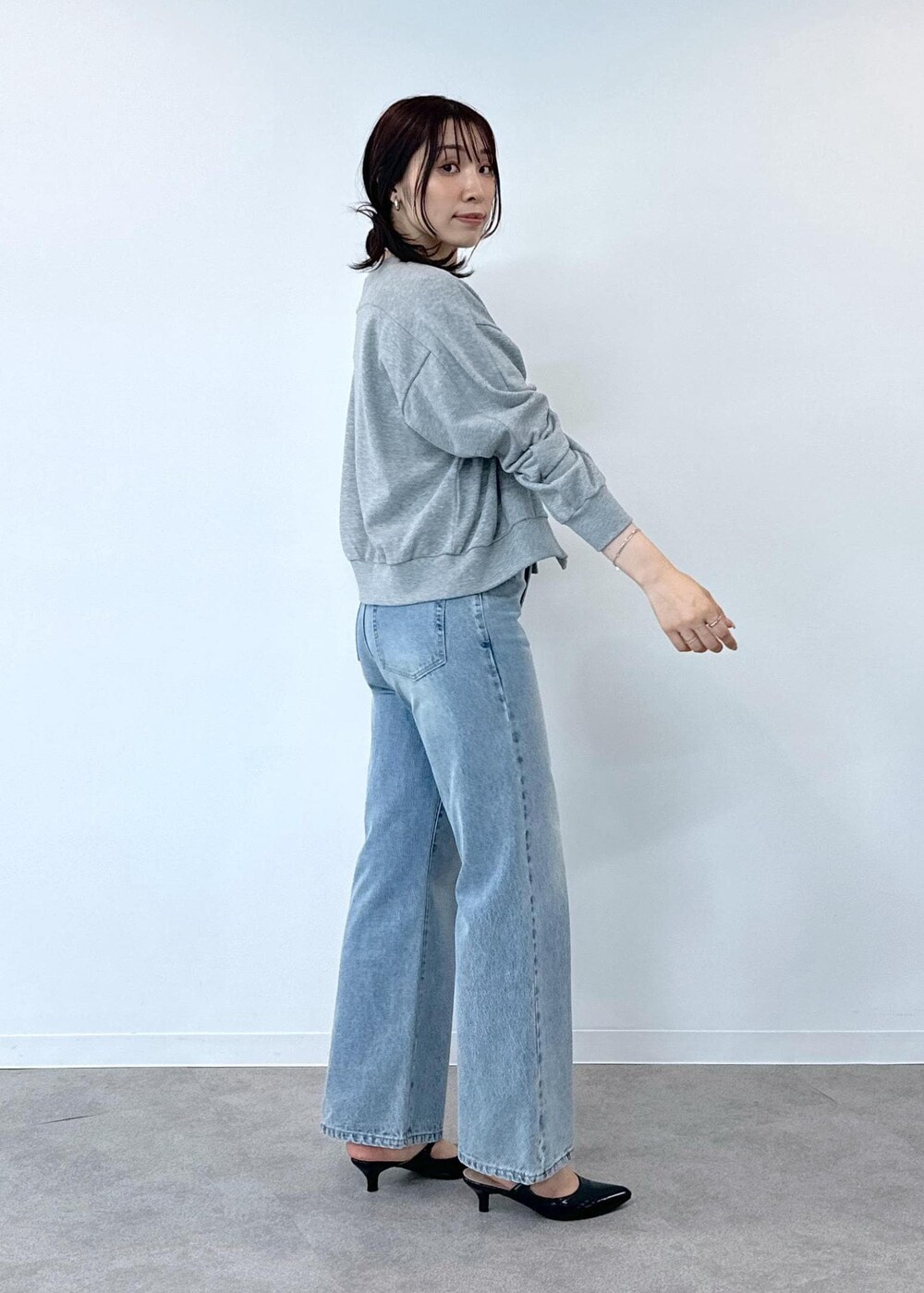 グレー系のデニムパンツ、ホワイト系のタンクトップ、ブラック系のショルダーバッグを着用したレディースの夏コーディネートの5枚目の写真