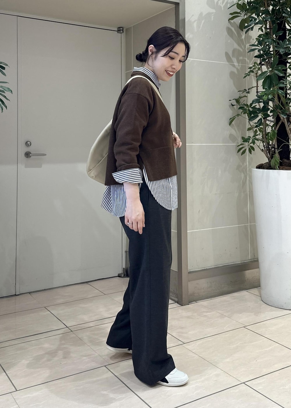 グレー系のその他パンツ、ブルー系のシャツ/ブラウス、ホワイト系のスニーカーを着用したレディースの冬コーディネートの3枚目の写真