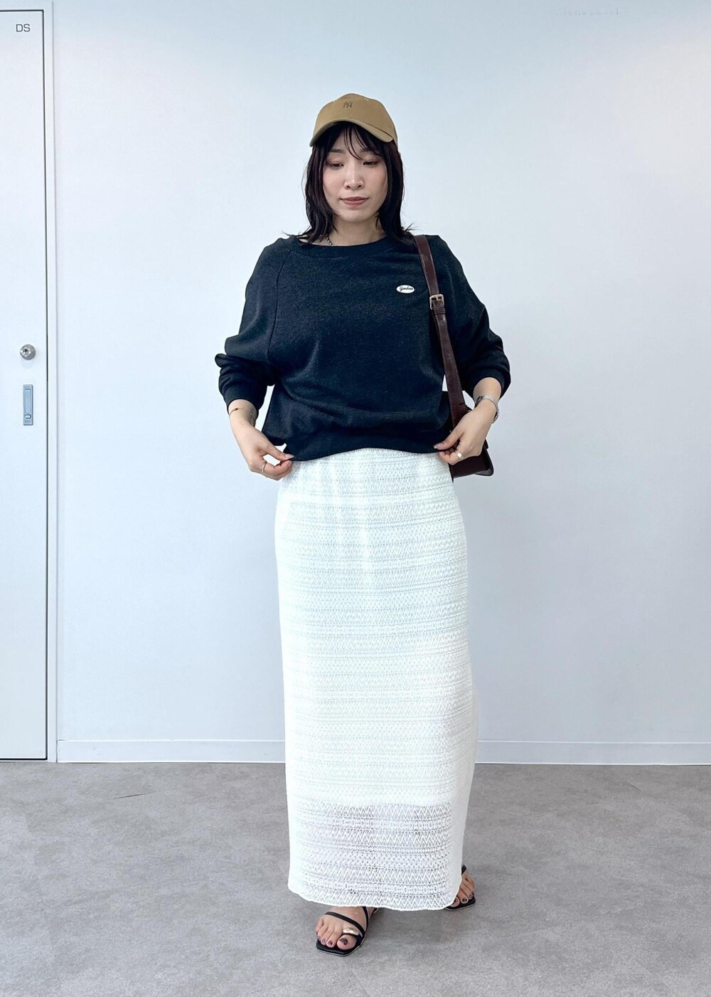 ブラック系のサンダル、ホワイト系のスカート、レッド系のショルダーバッグを着用したレディースの夏コーディネートの3枚目の写真