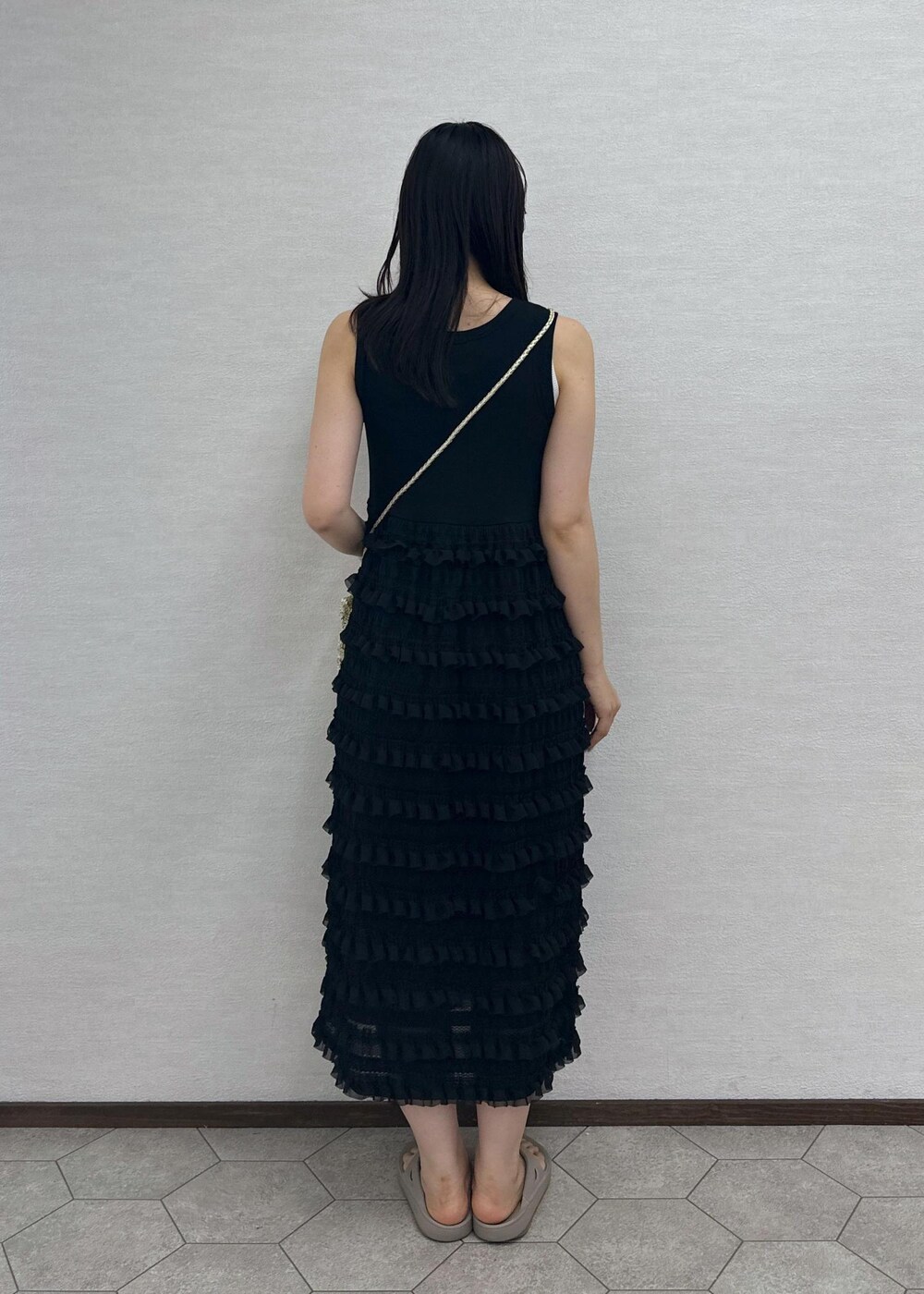 ゴールド系のショルダーバッグ、ブラック系のワンピース、ブラウン系のサングラスを着用したレディースの夏コーディネートの4枚目の写真