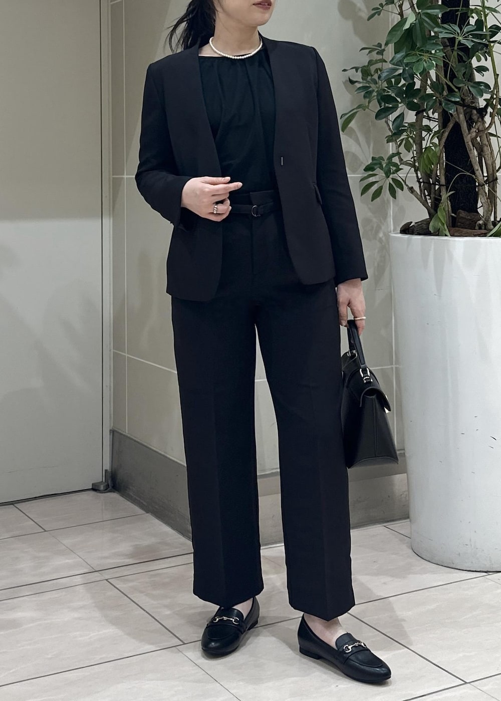 ブラック系のニット/セーター、ブラック系のローファー、ブラック系のノーカラージャケットを着用したレディースの冬コーディネートの7枚目の写真