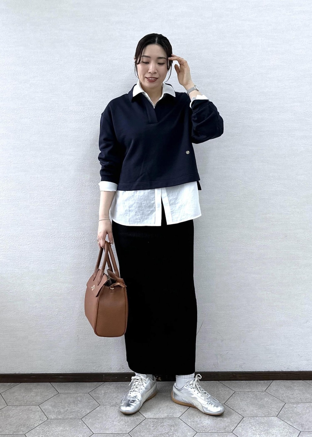 ブラック系のスカート、イエロー系のトートバッグ、ブルー系のスウェットを着用したレディースの春コーディネートの2枚目の写真