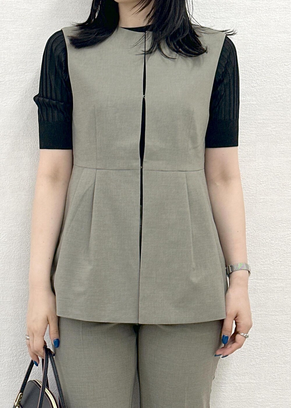 ブラック系のショルダーバッグ、ブラック系のニット/セーター、ブラウン系のその他パンツを着用したレディースの春コーディネートの5枚目の写真