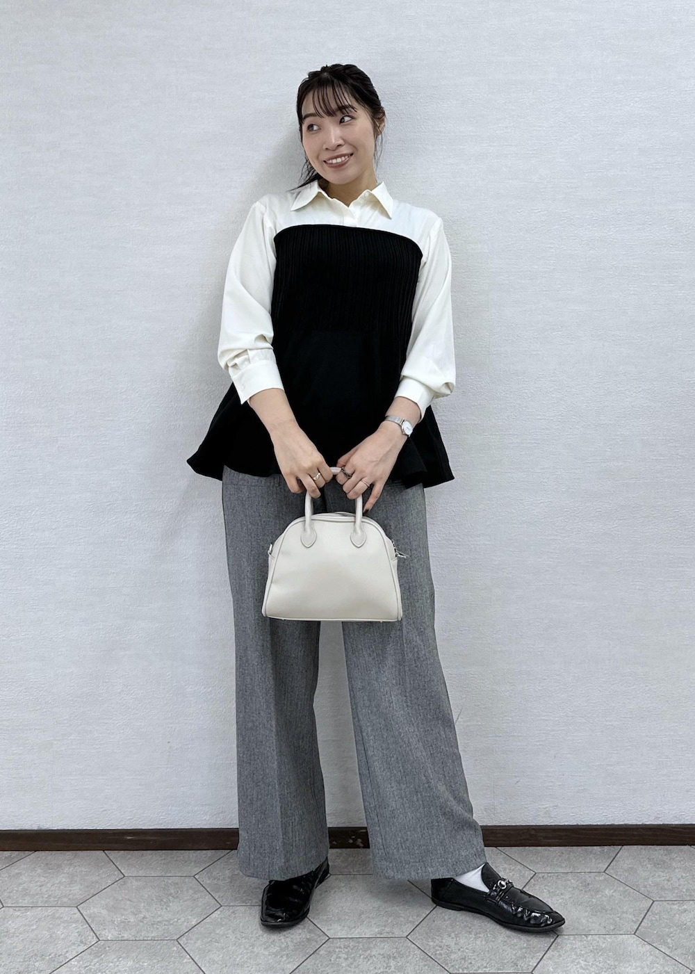 ブラック系のシャツ/ブラウス、グレー系のその他パンツ、ベージュ系のボストンバッグを着用したレディースの秋コーディネートの4枚目の写真