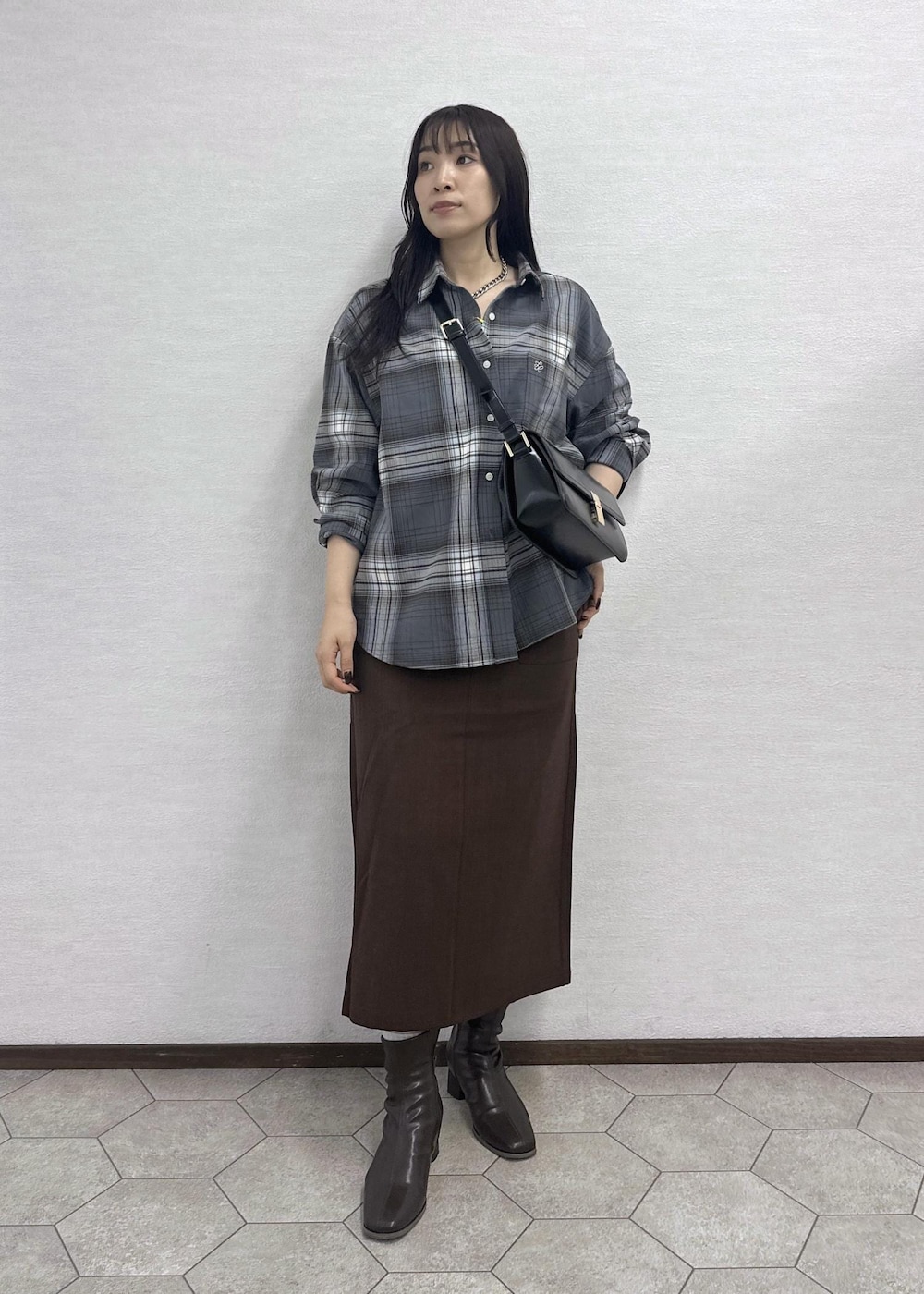 ブラウン系のスカート、ブラック系のショルダーバッグ、グレー系のシャツ/ブラウスを着用したレディースの秋コーディネートの2枚目の写真