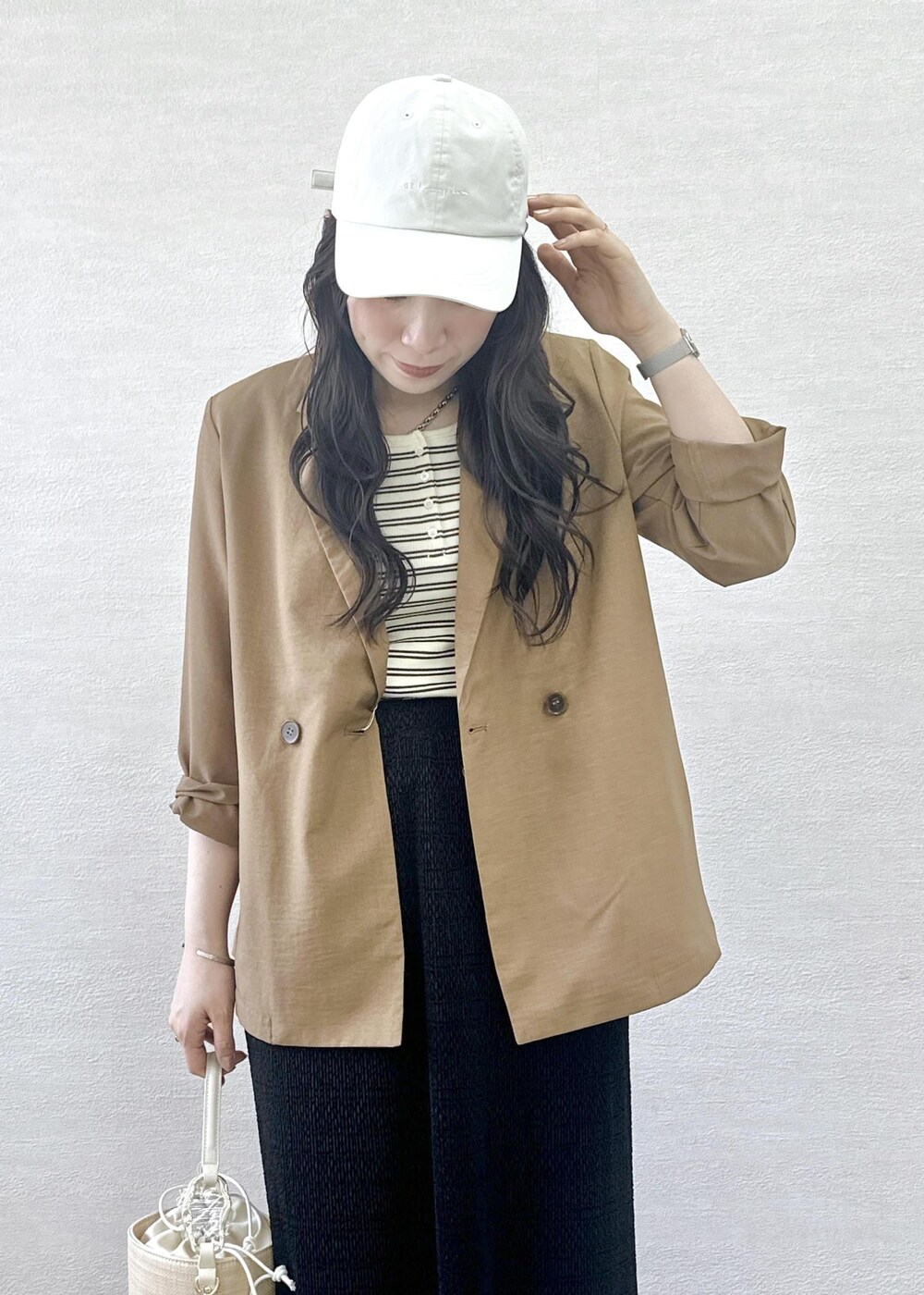 ブラウン系のパンプス、イエロー系のテーラードジャケット、ホワイト系のタンクトップを着用したレディースの春コーディネートの9枚目の写真
