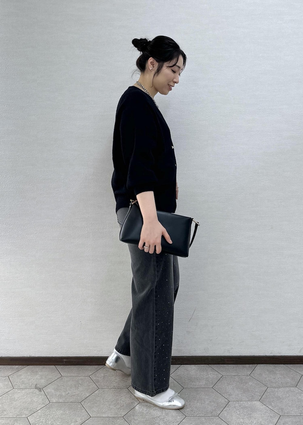 シルバー系のバレエシューズ、ブラック系のデニムパンツ、ブラック系のショルダーバッグを着用したレディースの冬コーディネートの4枚目の写真