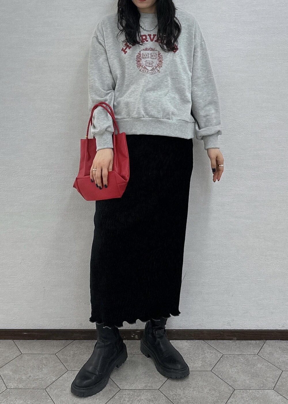 グレー系のスウェット、レッド系のトートバッグ、ブラック系のスカートを着用したレディースの冬コーディネートの5枚目の写真