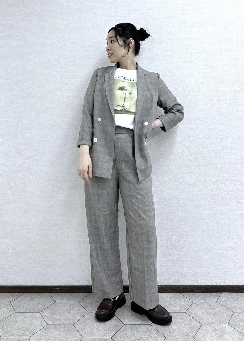 ベージュ系のテーラードジャケット、ベージュ系のスラックス、ホワイト系のTシャツ/カットソーを着用したレディースの春コーディネートの2枚目の写真