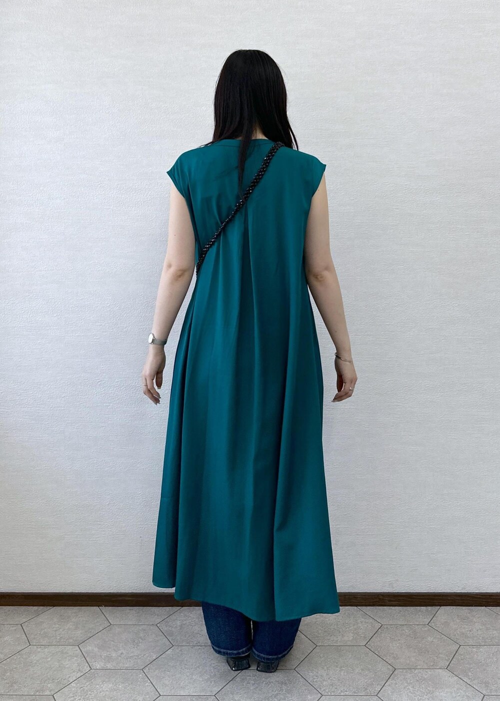 ブラック系のショルダーバッグ、ブルー系のデニムパンツ、グリーン系のワンピースを着用したレディースの夏コーディネートの5枚目の写真