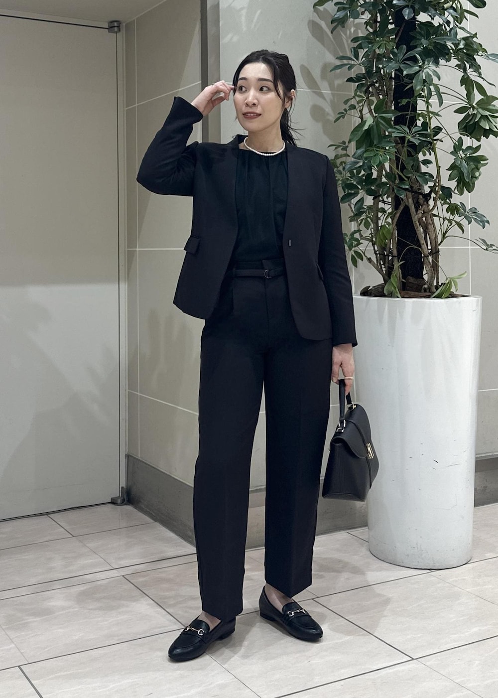 ブラック系のニット/セーター、ブラック系のローファー、ブラック系のノーカラージャケットを着用したレディースの冬コーディネートの3枚目の写真