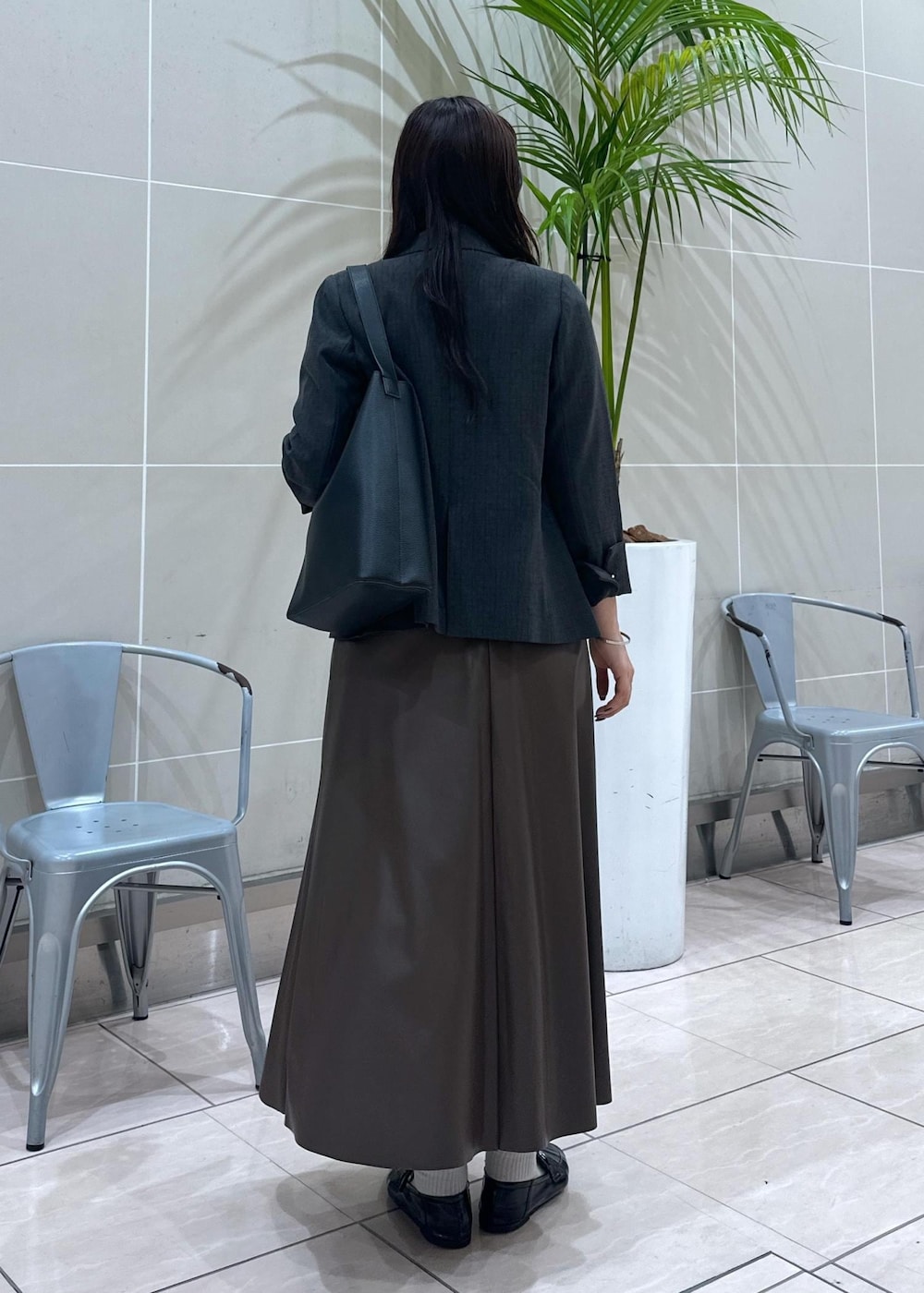 ブラック系のショルダーバッグ、ブラック系のテーラードジャケット、ブラウン系のスカートを着用したレディースの秋コーディネートの6枚目の写真