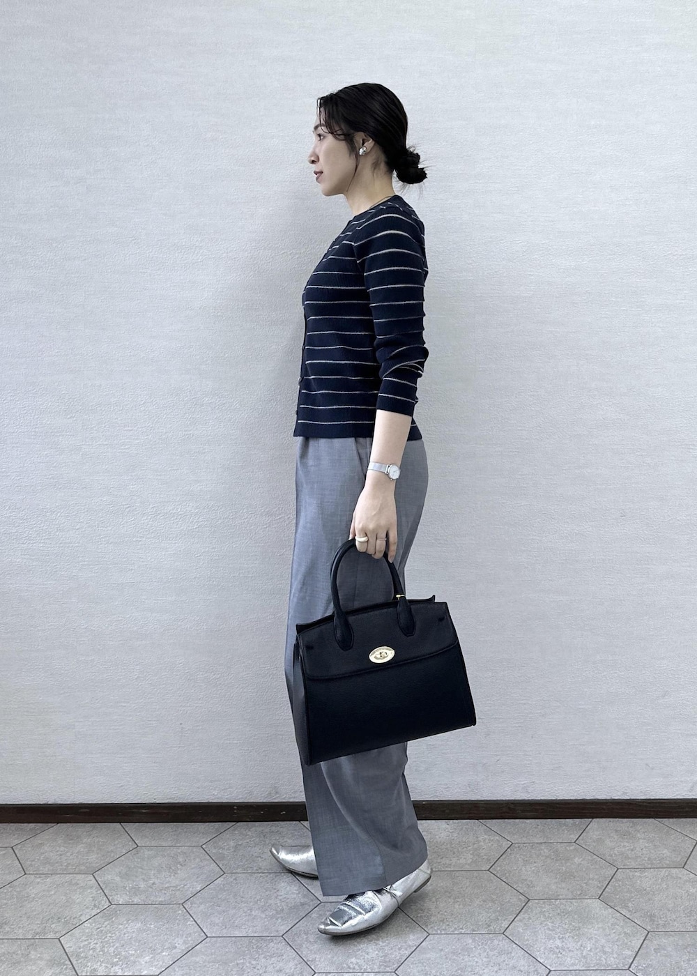 ブラック系のトートバッグ、ブラック系のタンクトップ、ブルー系のカーディガン/ボレロを着用したレディースの春コーディネートの5枚目の写真