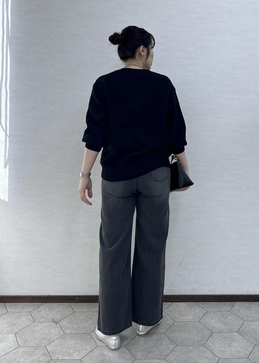 シルバー系のバレエシューズ、ブラック系のデニムパンツ、ブラック系のショルダーバッグを着用したレディースの冬コーディネートの5枚目の写真