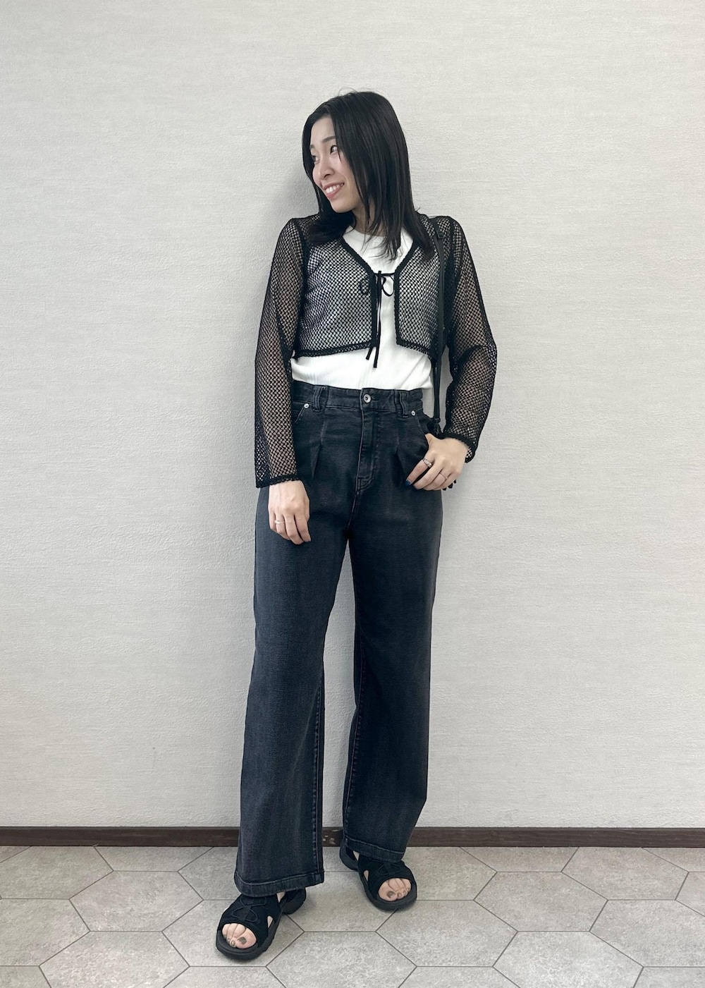 ブラック系のサンダル、ブラック系のデニムパンツ、ブラック系のカーディガン/ボレロを着用したレディースの夏コーディネートの3枚目の写真
