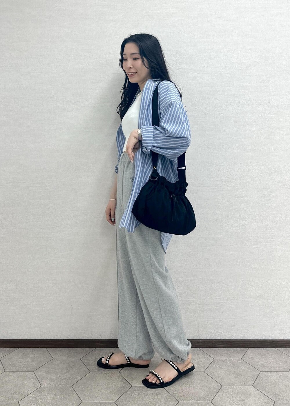 ブラック系のサンダル、ブラック系のショルダーバッグ、ホワイト系のタンクトップを着用したレディースの春コーディネートの3枚目の写真