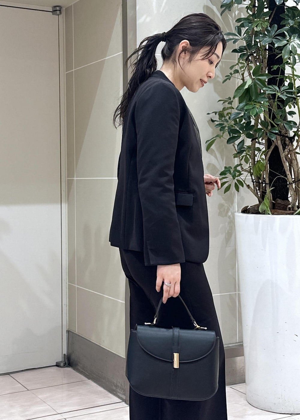 ブラック系のニット/セーター、ブラック系のローファー、ブラック系のノーカラージャケットを着用したレディースの冬コーディネートの9枚目の写真