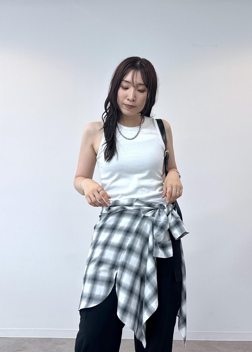 ブラック系のカーゴパンツ、ホワイト系のタンクトップ、ブラック系のショルダーバッグを着用したレディースの夏コーディネートの9枚目の写真