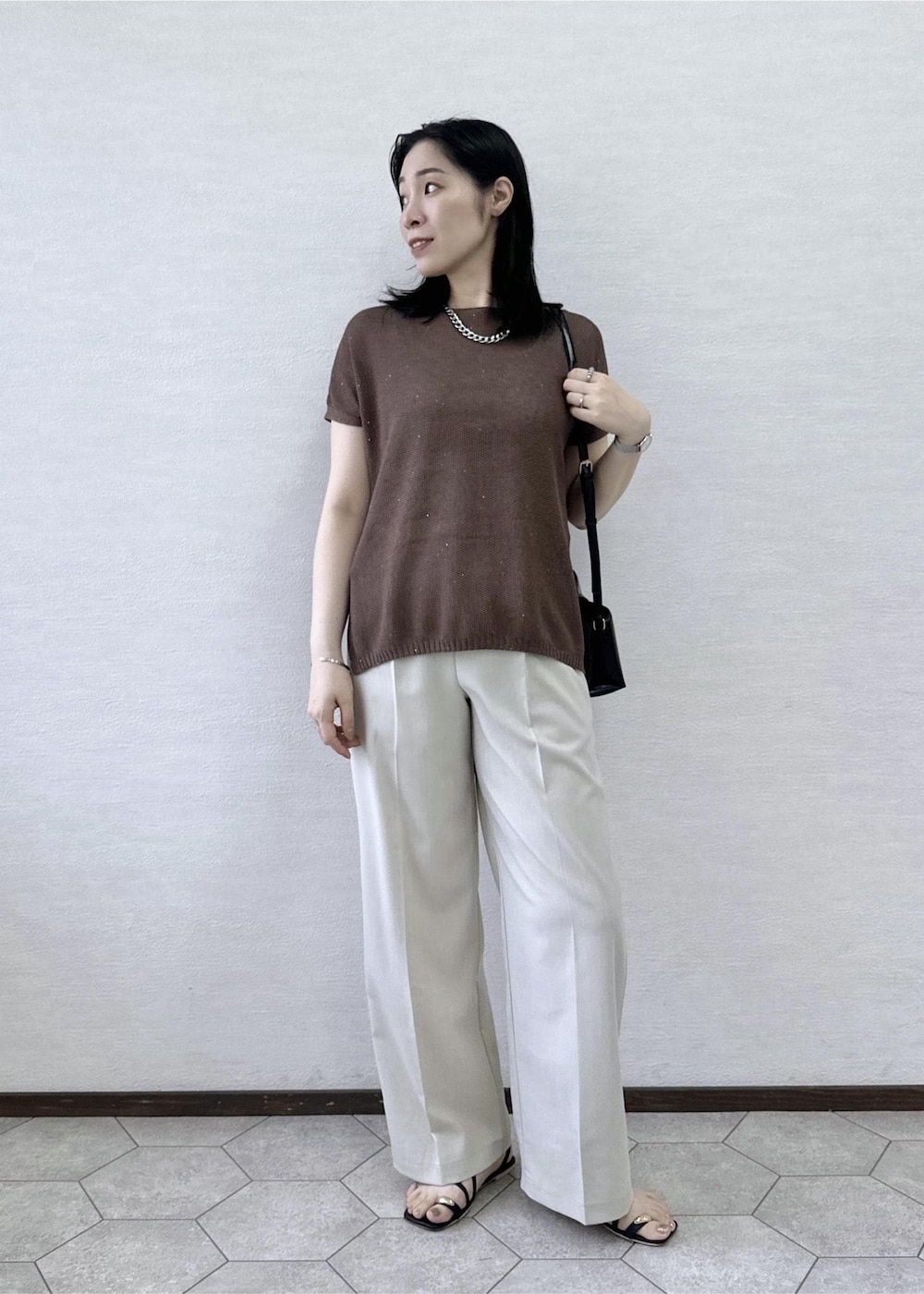 ベージュ系のその他パンツ、ブラック系のショルダーバッグ、イエロー系のニット/セーターを着用したレディースの夏コーディネートの4枚目の写真