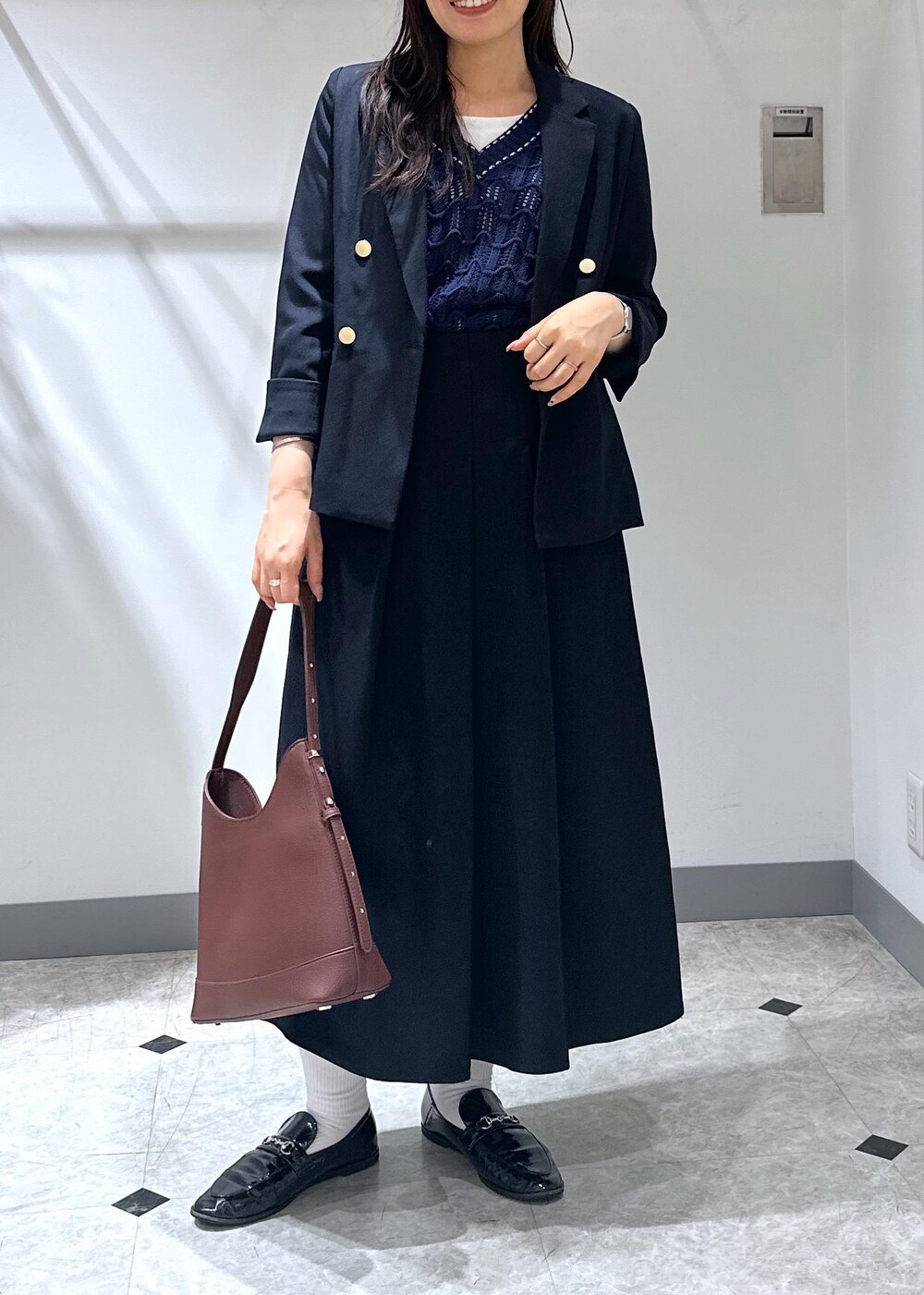 ブルー系のベスト、レッド系のショルダーバッグ、ホワイト系のタンクトップを着用したレディースの夏コーディネートの7枚目の写真