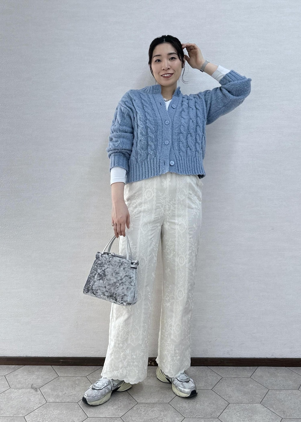 シルバー系のハンドバッグ、ホワイト系のその他パンツ、ブルー系のカーディガン/ボレロを着用したレディースの冬コーディネートの2枚目の写真