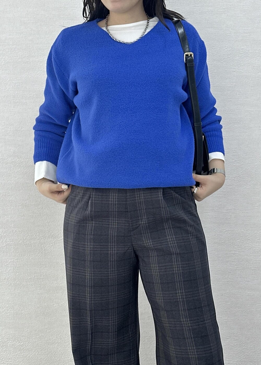 ブラック系のショルダーバッグ、ブルー系のニット/セーター、ホワイト系のTシャツ/カットソーを着用したレディースの秋コーディネートの8枚目の写真