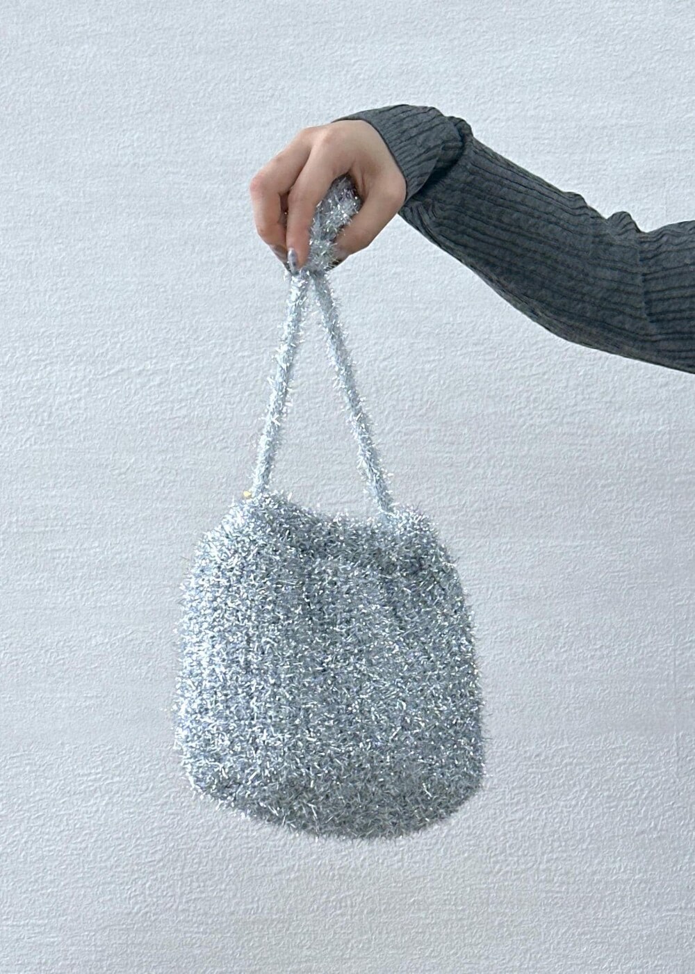 ブラック系のスカート、グレー系のカーディガン/ボレロ、シルバー系のショルダーバッグを着用したレディースの秋コーディネートの5枚目の写真