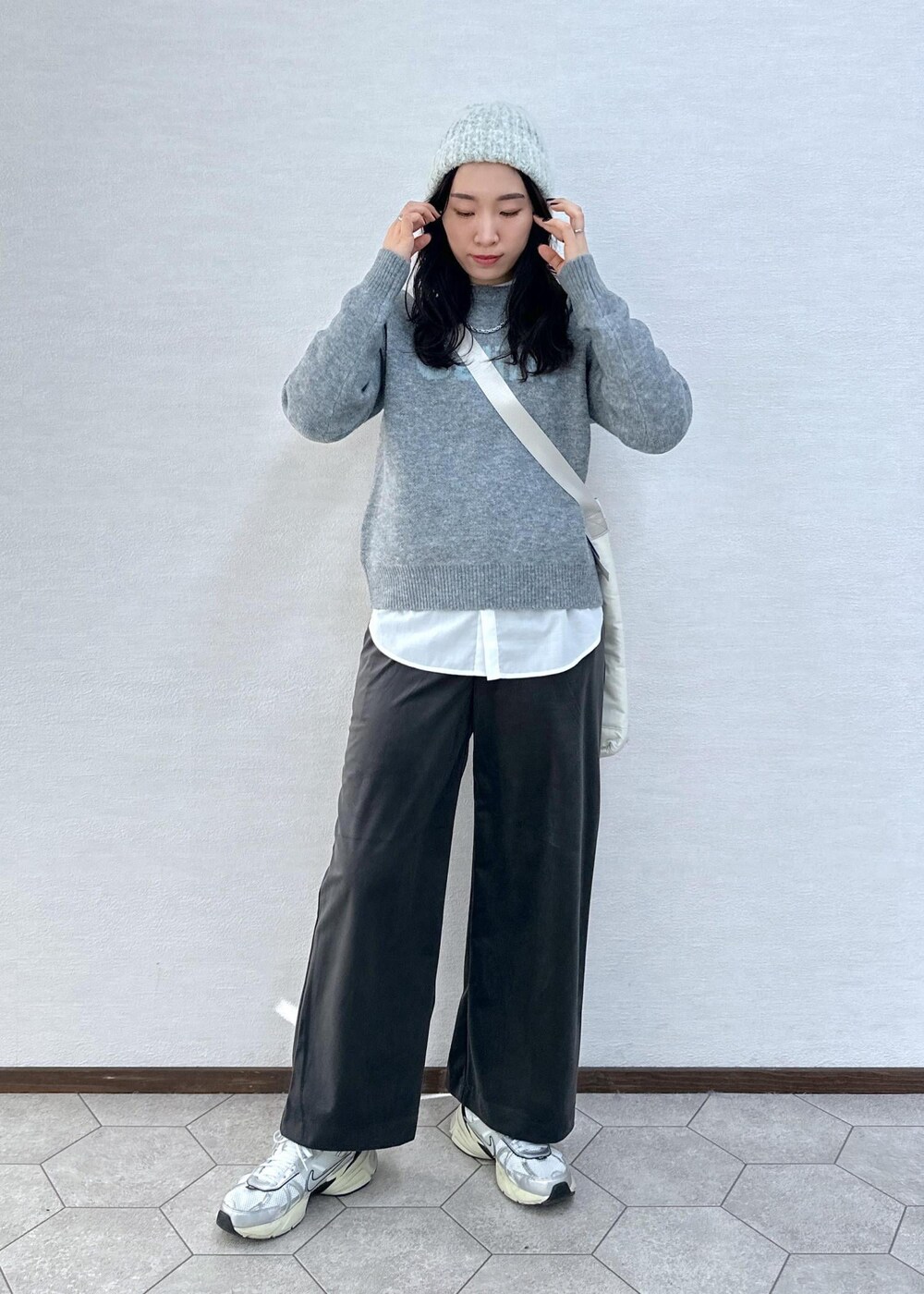 グレー系のニット/セーター、グレー系のその他パンツ、ホワイト系のトートバッグを着用したレディースの冬コーディネートの3枚目の写真