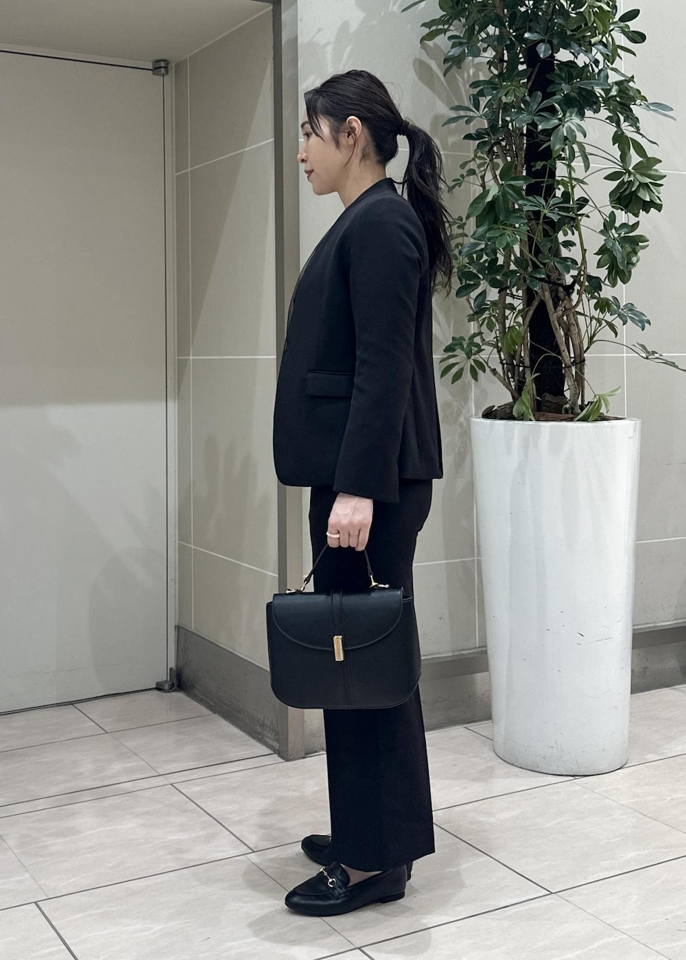 ブラック系のニット/セーター、ブラック系のローファー、ブラック系のノーカラージャケットを着用したレディースの冬コーディネートの4枚目の写真