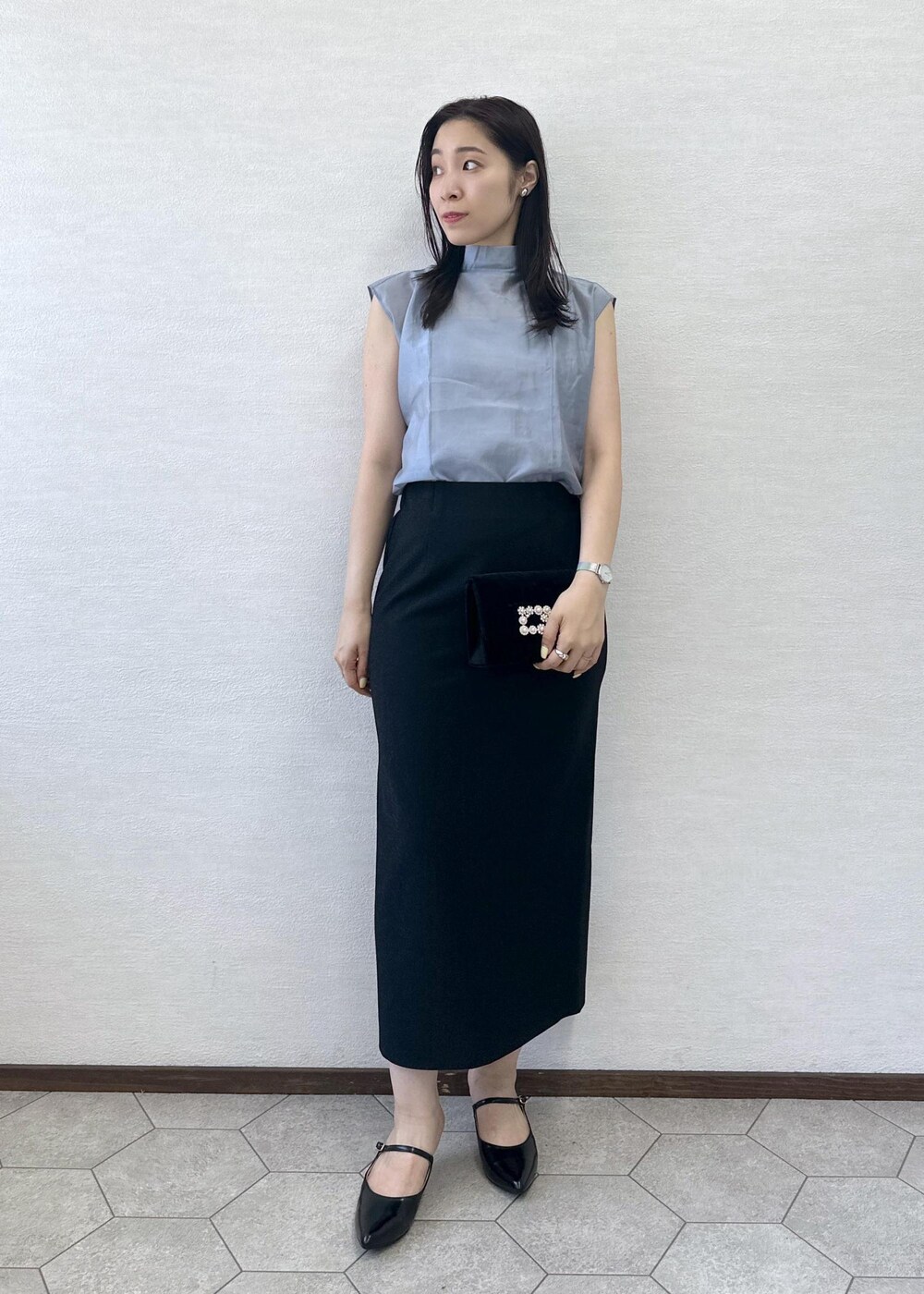 ブラック系のショルダーバッグ、ブラック系のスカート、ブラック系のパンプスを着用したレディースの夏コーディネートの2枚目の写真