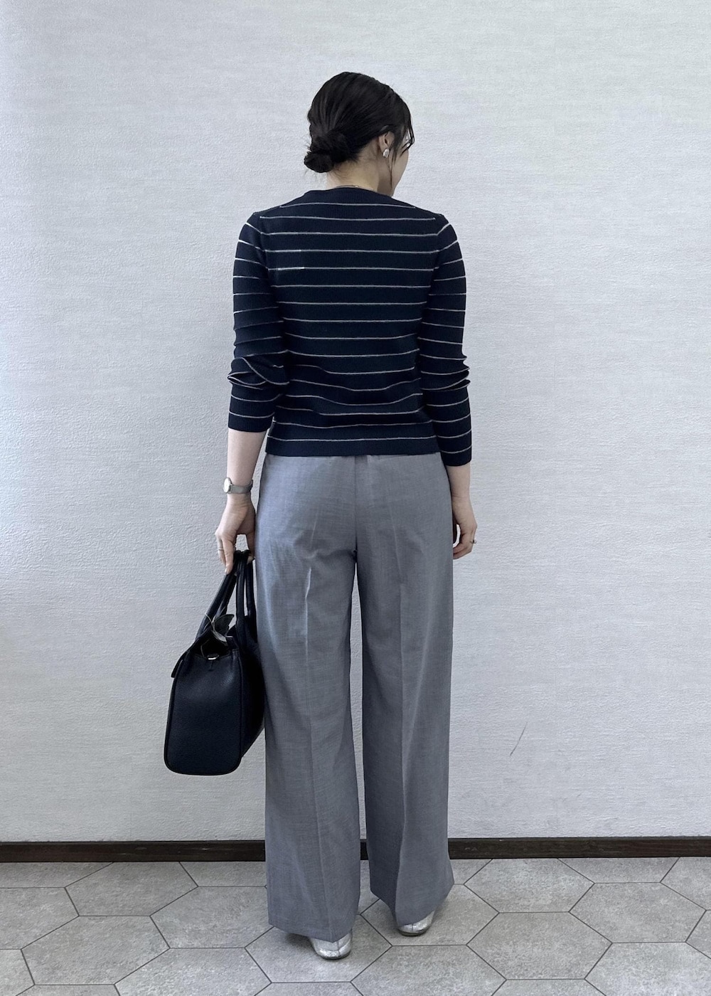 ブラック系のトートバッグ、ブラック系のタンクトップ、ブルー系のカーディガン/ボレロを着用したレディースの春コーディネートの6枚目の写真