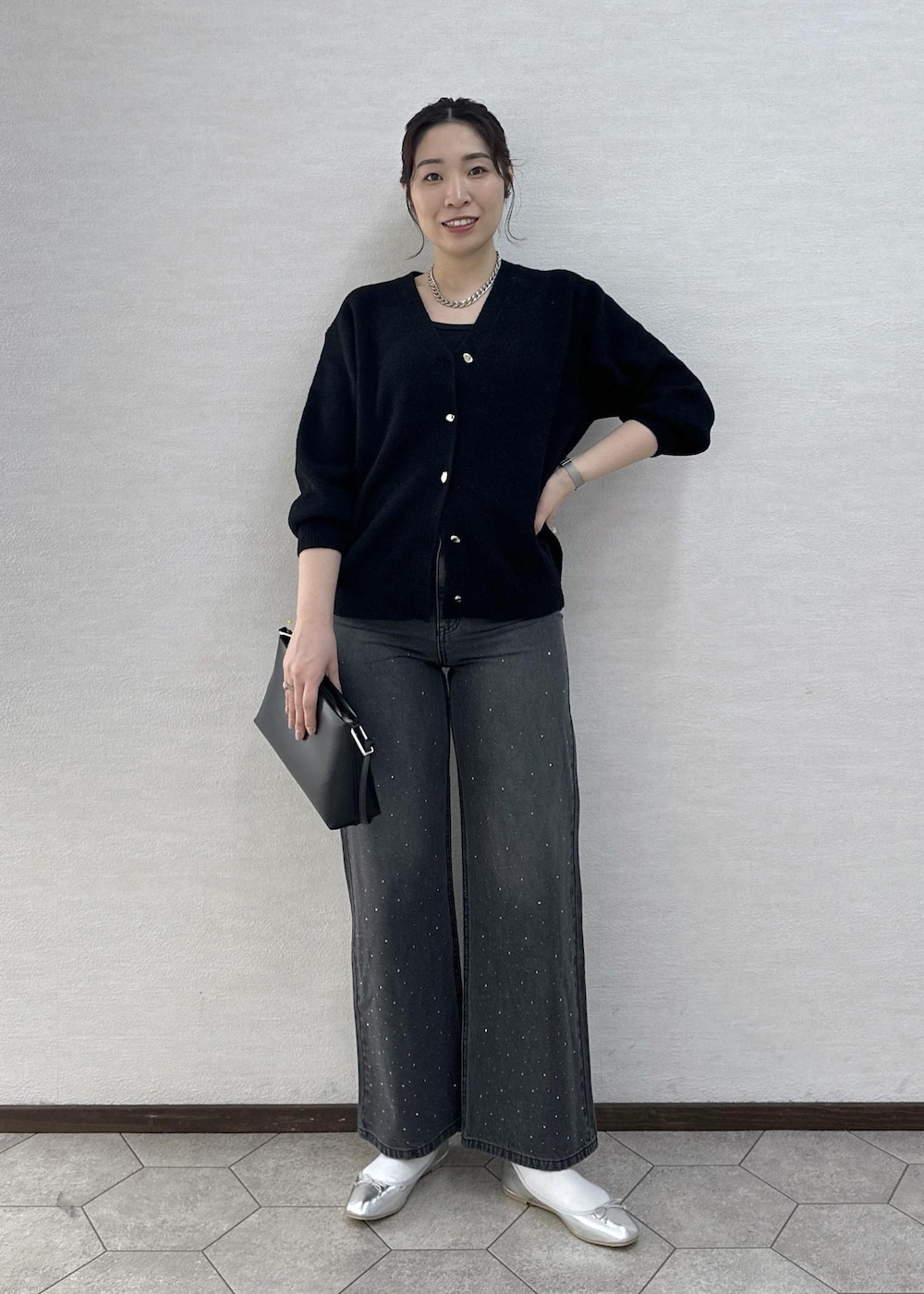 シルバー系のバレエシューズ、ブラック系のデニムパンツ、ブラック系のショルダーバッグを着用したレディースの冬コーディネートの3枚目の写真