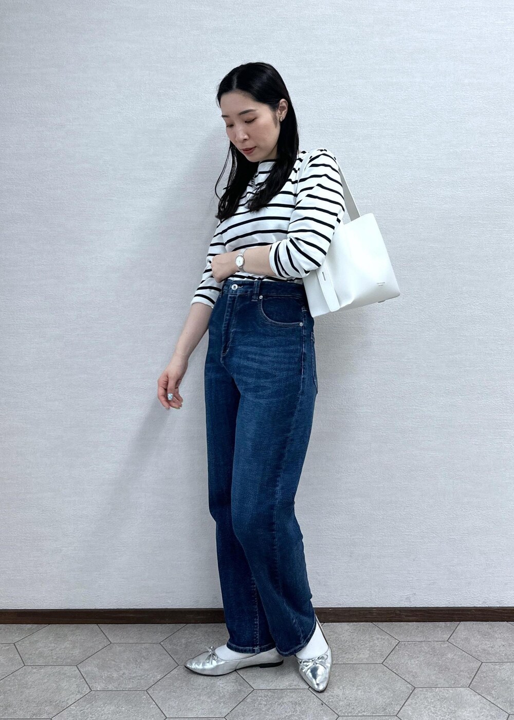 ホワイト系のTシャツ/カットソー、ブルー系のデニムパンツ、ホワイト系のショルダーバッグを着用したレディースの春コーディネートの3枚目の写真