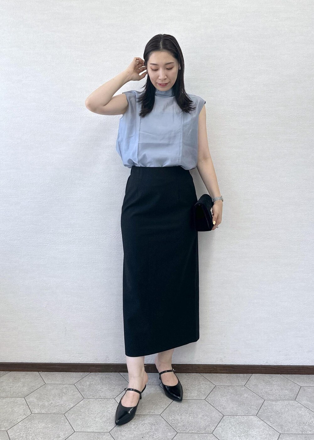 ブラック系のショルダーバッグ、ブラック系のスカート、ブラック系のパンプスを着用したレディースの夏コーディネートの3枚目の写真