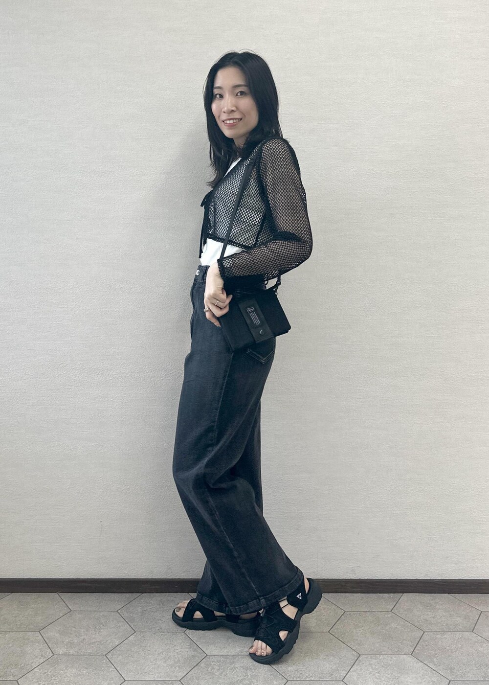 ブラック系のサンダル、ブラック系のデニムパンツ、ブラック系のカーディガン/ボレロを着用したレディースの夏コーディネートの2枚目の写真