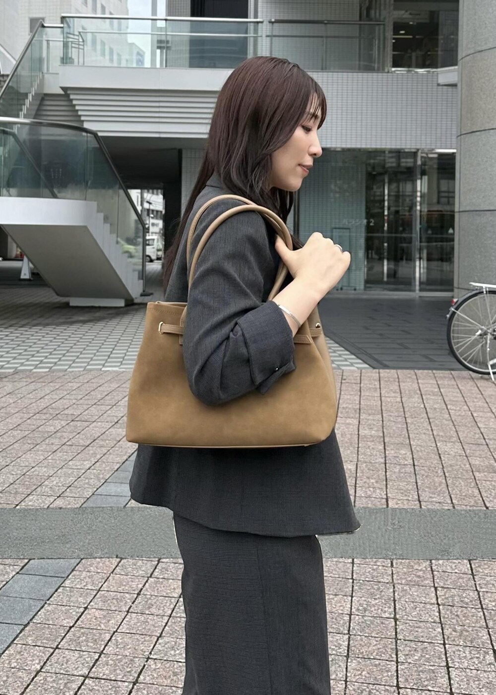 ブラック系のタンクトップ、イエロー系のトートバッグ、ブラック系のテーラードジャケットを着用したレディースの秋コーディネートの5枚目の写真