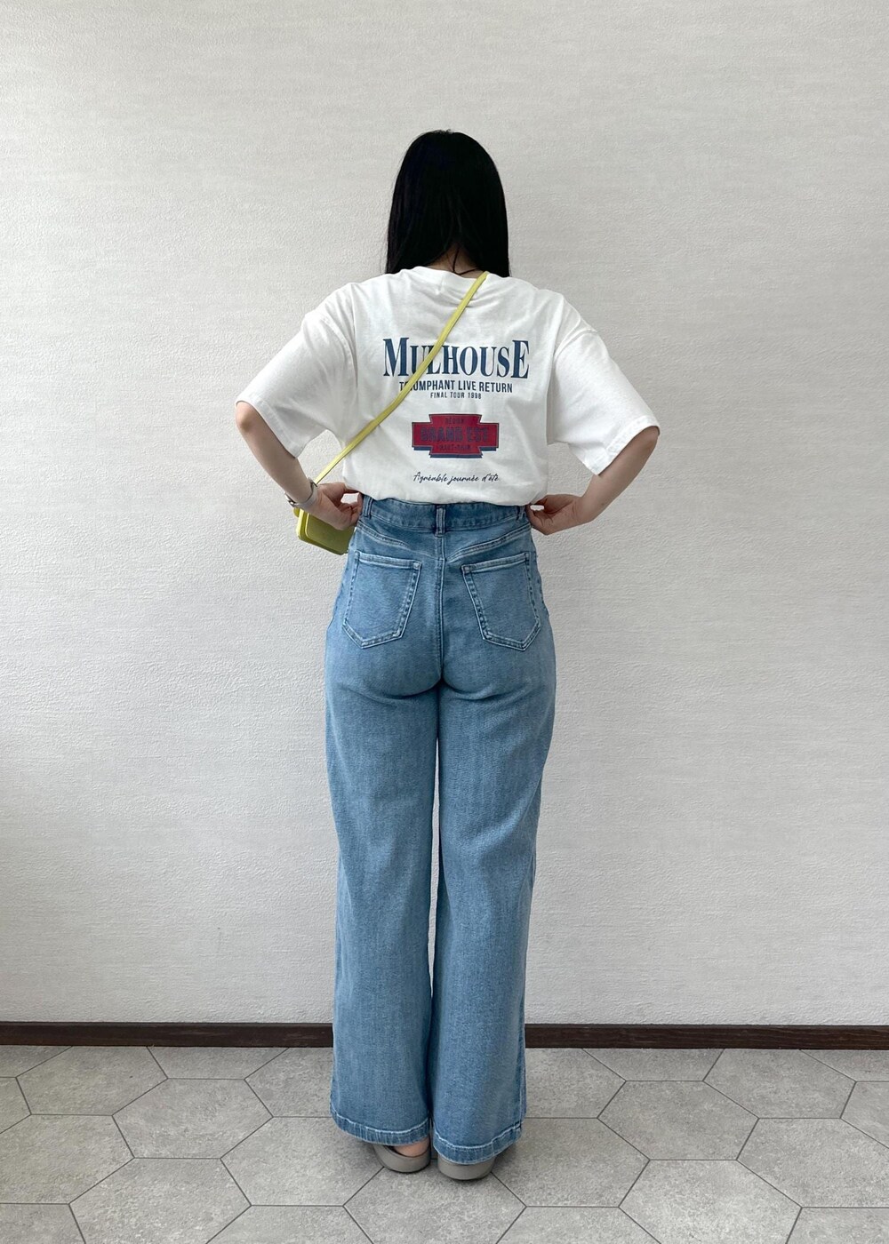 イエロー系のショルダーバッグ、ブルー系のデニムパンツ、ホワイト系のTシャツ/カットソーを着用したレディースの夏コーディネートの5枚目の写真