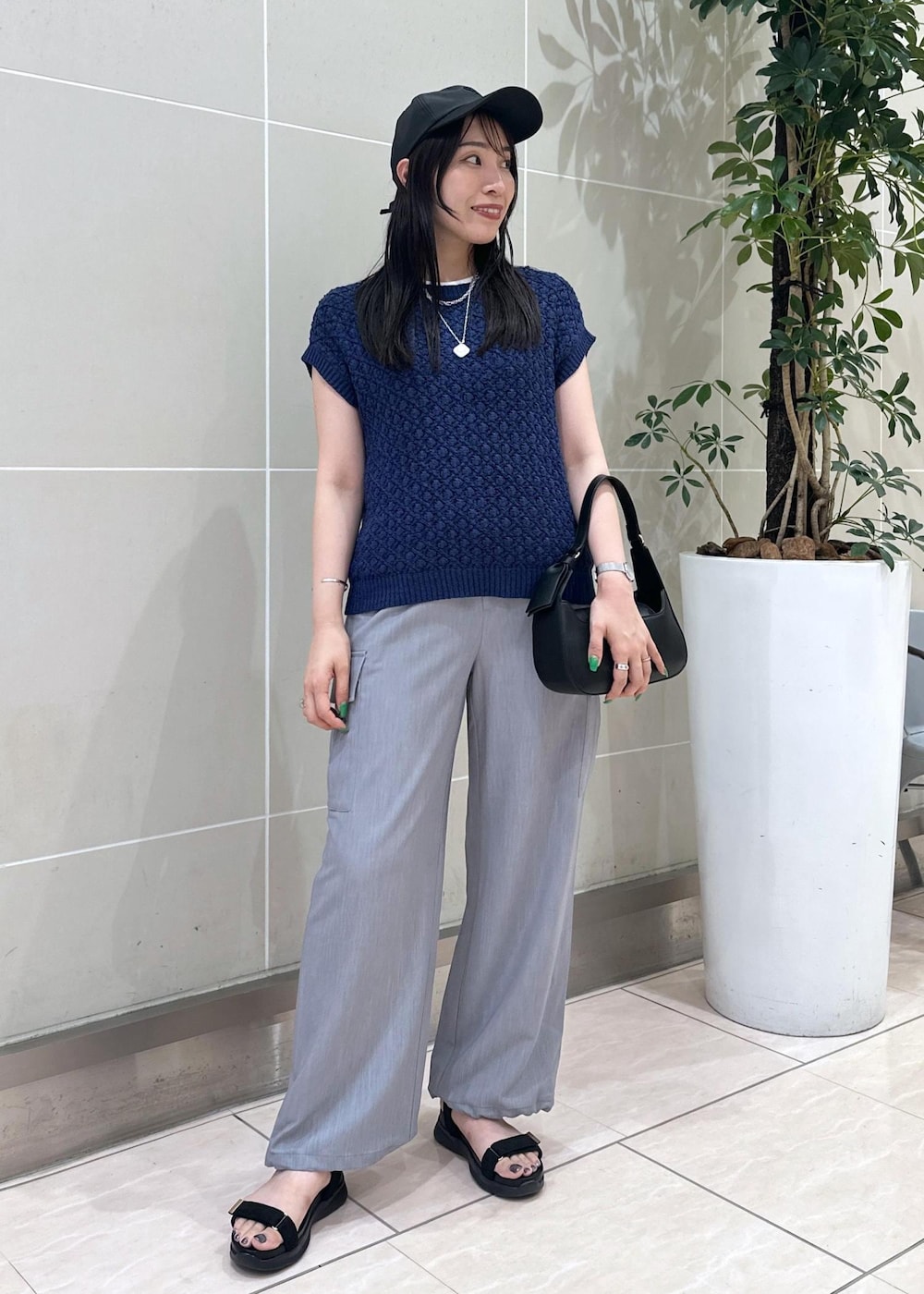 ブルー系のベスト、グレー系のカーゴパンツ、ブラック系のサンダルを着用したレディースの夏コーディネートの3枚目の写真