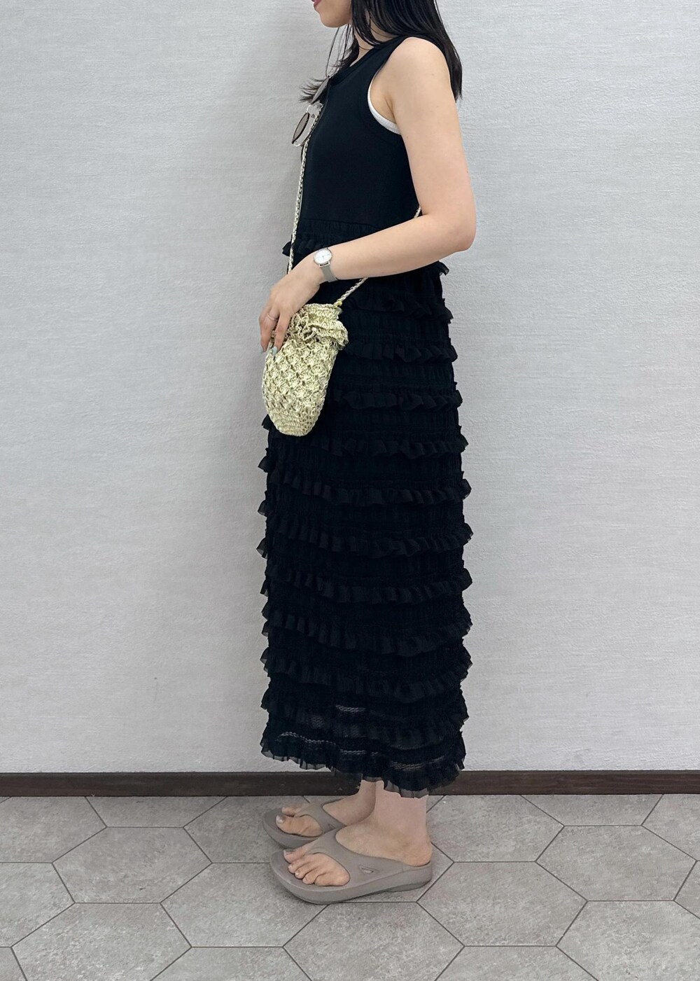 ゴールド系のショルダーバッグ、ブラック系のワンピース、ブラウン系のサングラスを着用したレディースの夏コーディネートの3枚目の写真