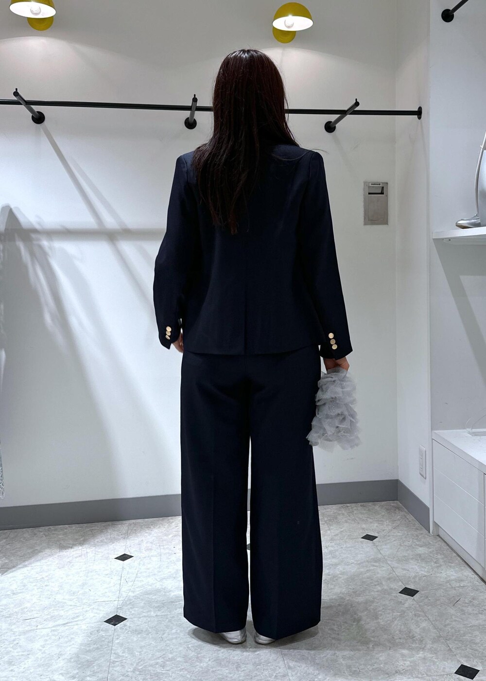 シルバー系のバレエシューズ、グレー系のショルダーバッグ、ブルー系のスラックスを着用したレディースの夏コーディネートの5枚目の写真